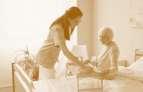 caregiver preparing food to senior